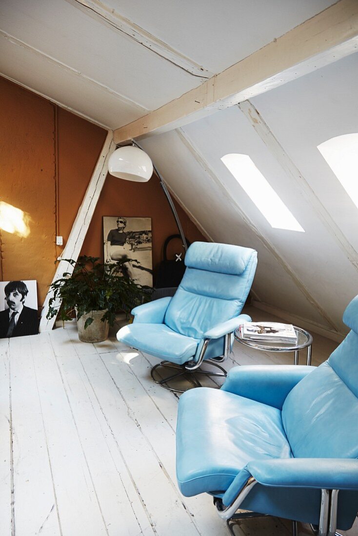 Pale blue leather armchairs and small side table in vintage attic room