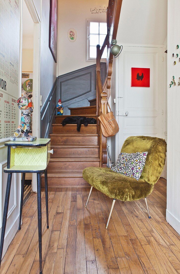 Retro easy chair with faux-fur upholstery in hallway of period building