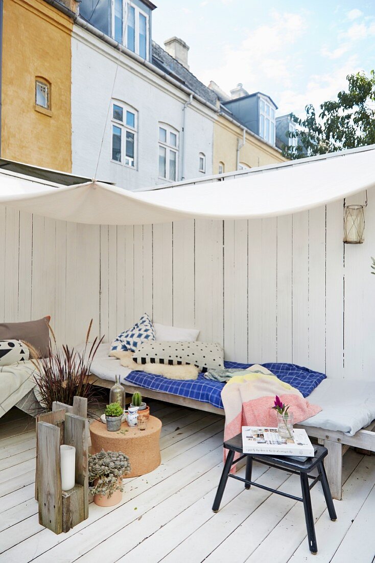 Comfortable wooden terrace below awning