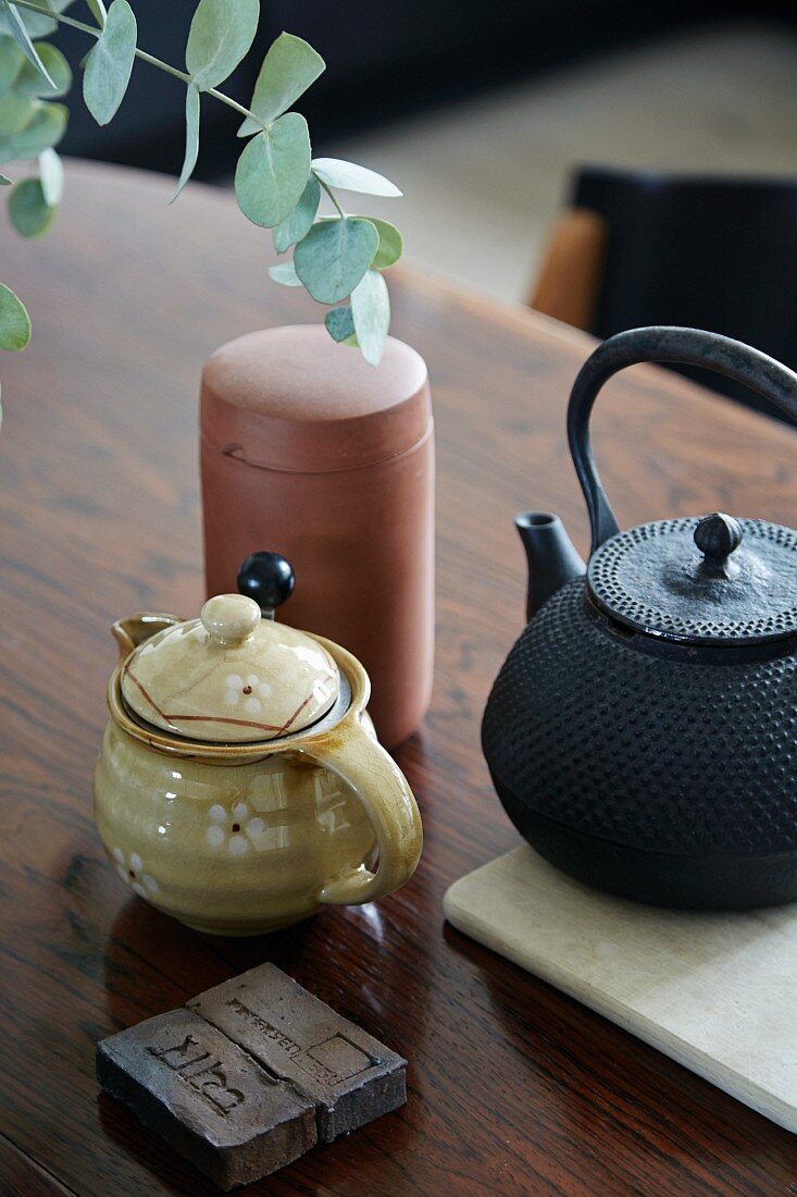 Oriental iron teapot, milk jugs and pot