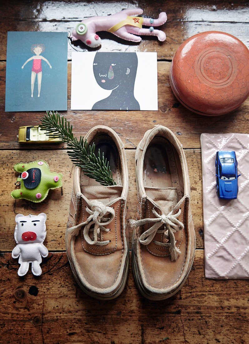 Toy car, cards, shoes and pine sprig on vintage wooden floor