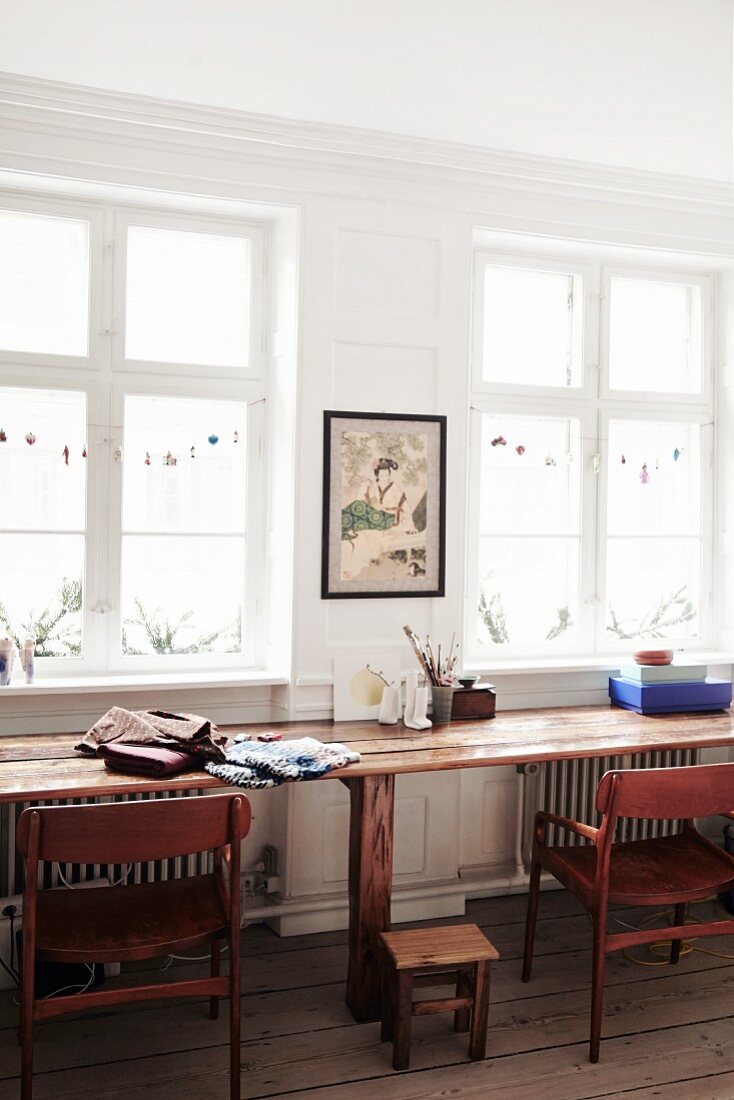 Dezent weihnachtlich dekorierte Sprossenfenster in Altbauwohnung mit langem rustikalem Holztisch