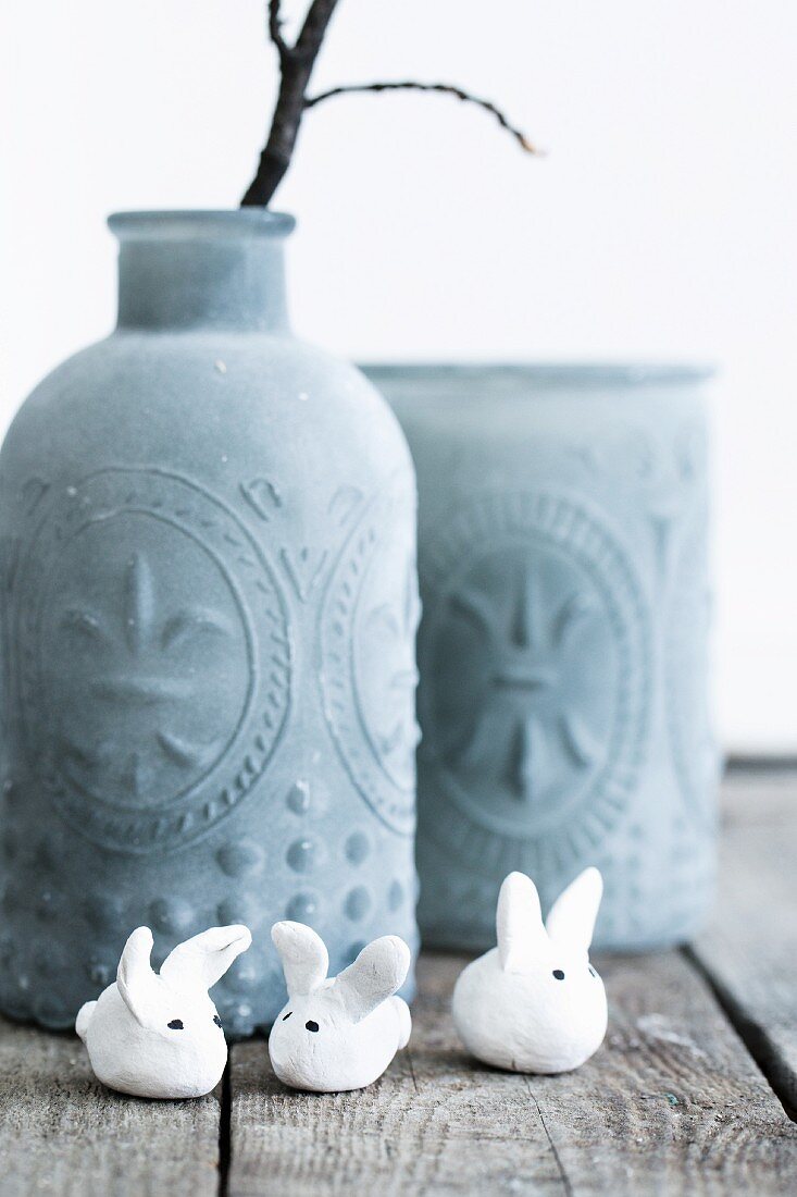 Tiny polymer clay rabbit in front of vase with structured surface