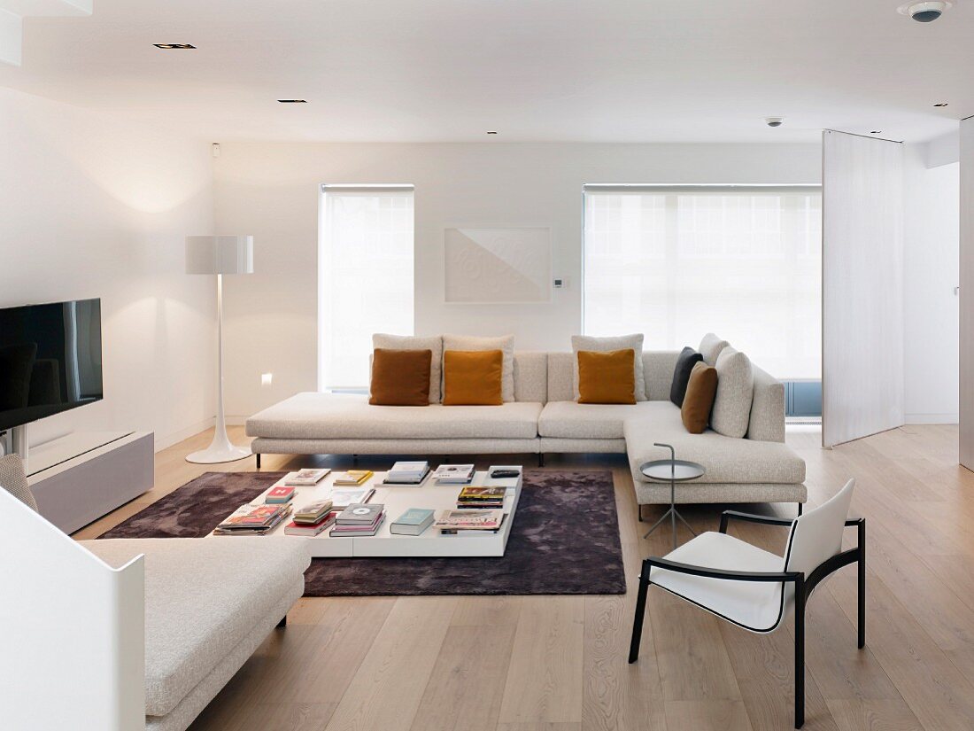 Modernes Wohnzimmer mit hellen Möbeln und Holzboden