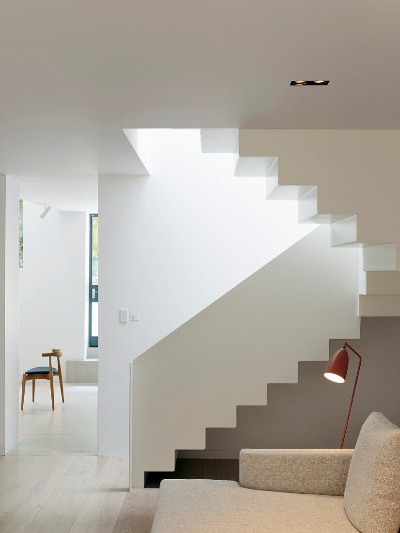 White staircase in bright, open-plan apartment