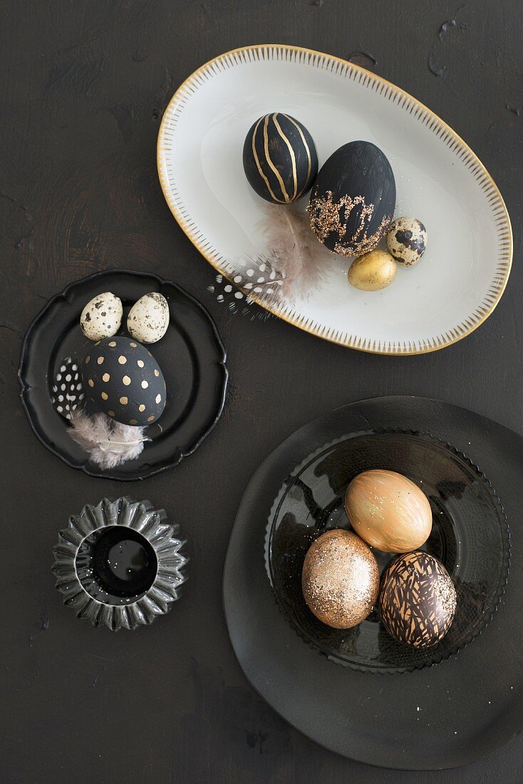 Black and gold Easter eggs on white and black crockery
