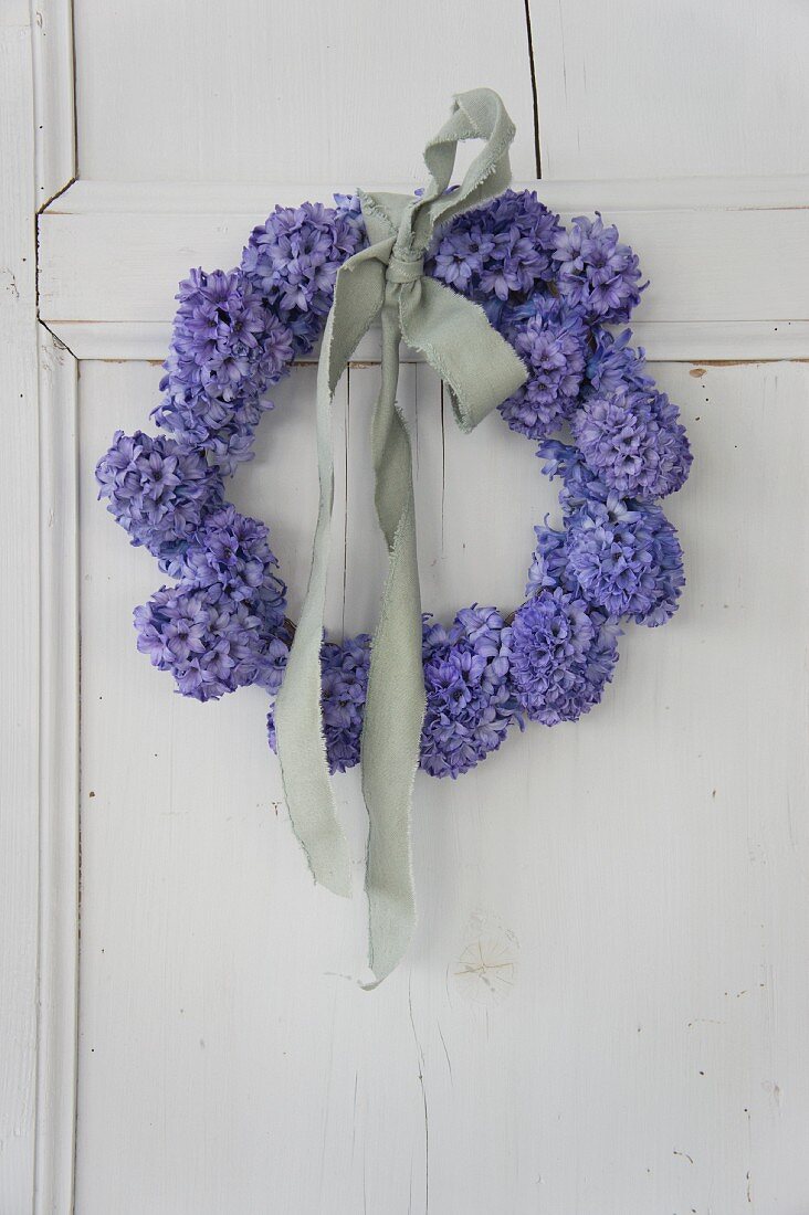 Wreath of blue hyacinths tied with pale fabric ribbon