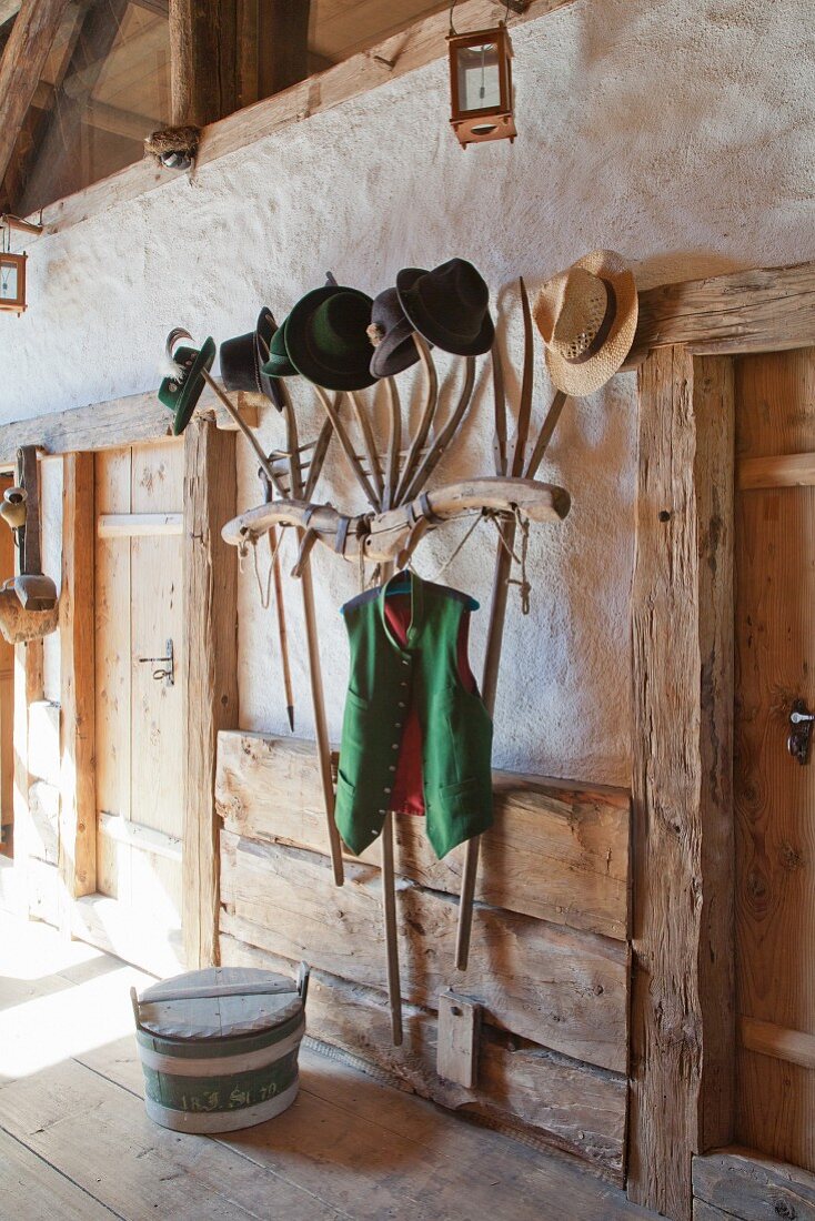 Collection of hats on coat rack made from old pitchforks and yoke