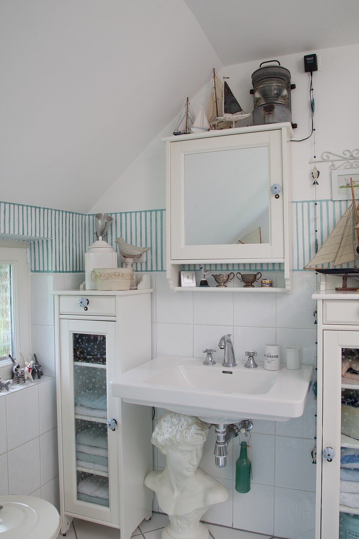 White cabinets and bust in maritime bathroom