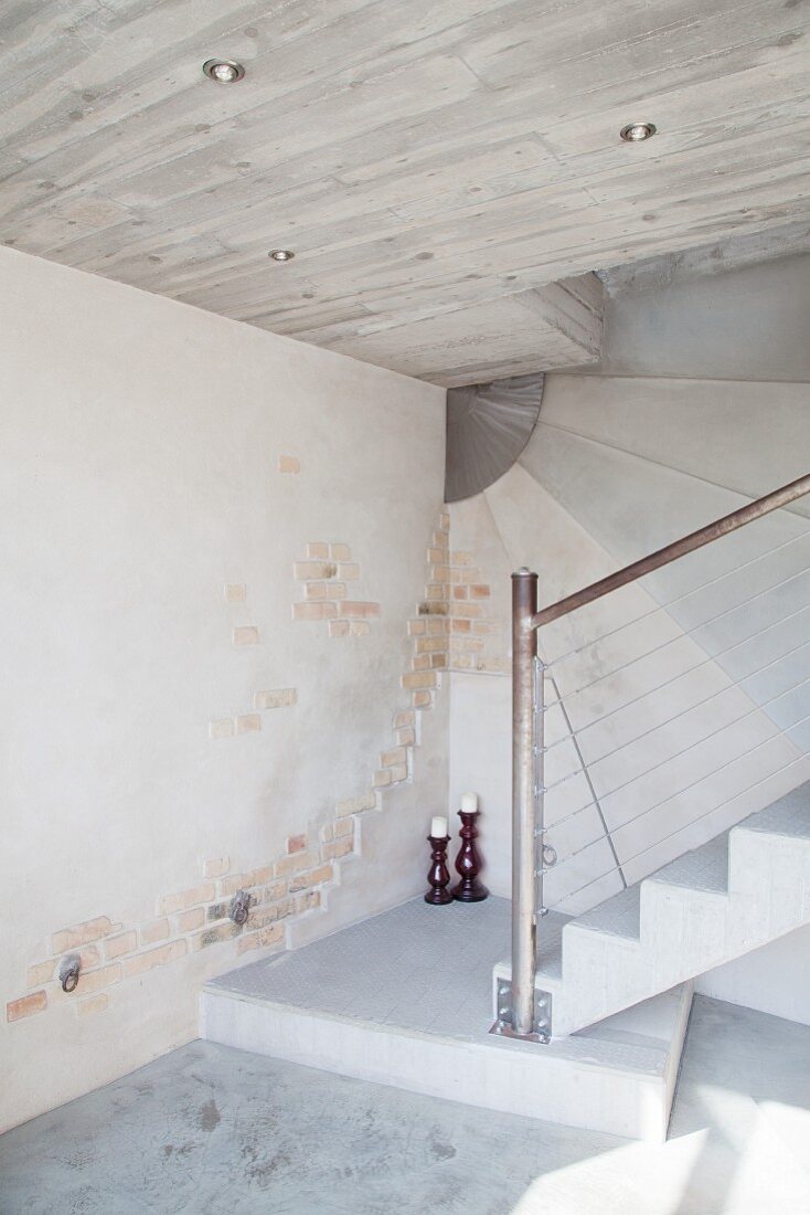 Concrete staircase with steel balustrade and concrete and brick walls