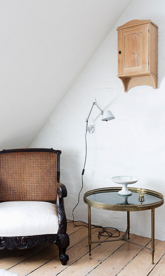 Barocker Sessel und runder Beistelltisch unterm Wandschrank