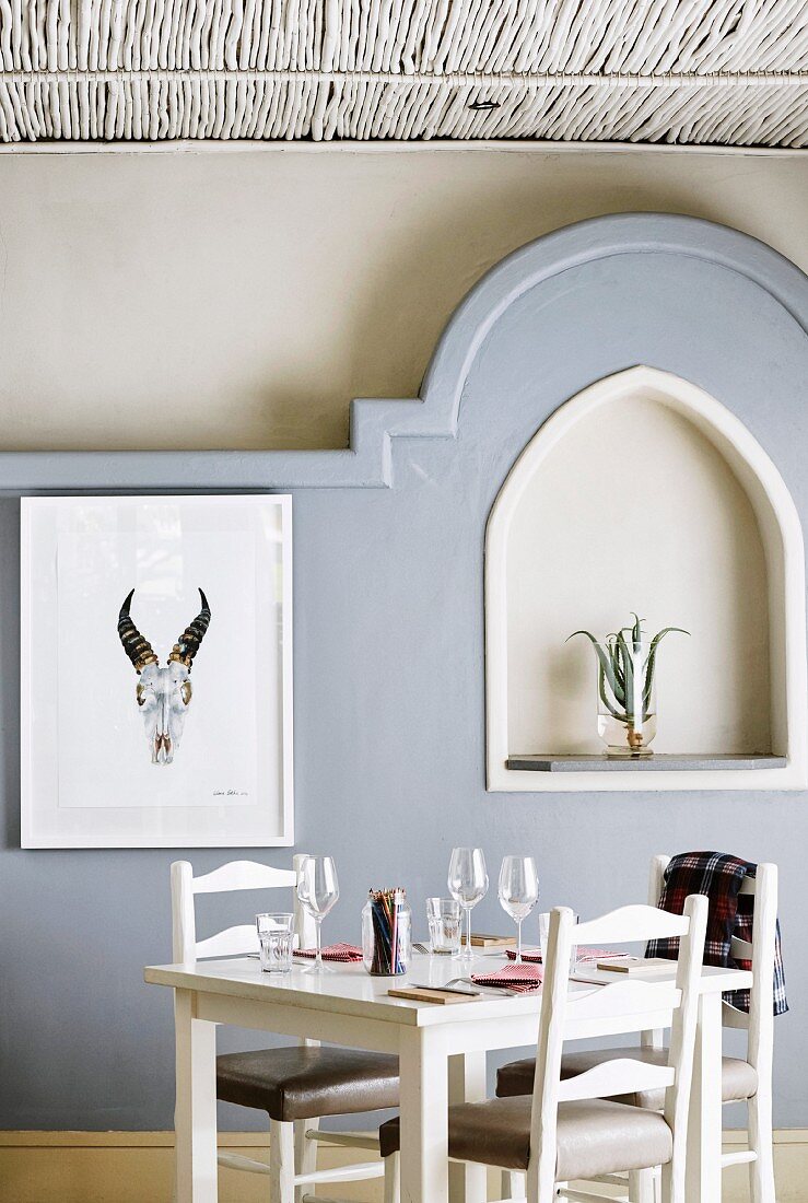 Set table in front of wall with 3D mouldings and niche