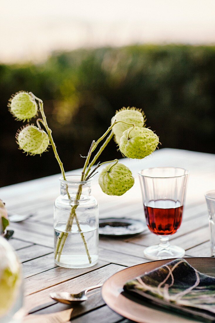 Ein Glas Rotwein und herbstliche Derkoration auf Tisch