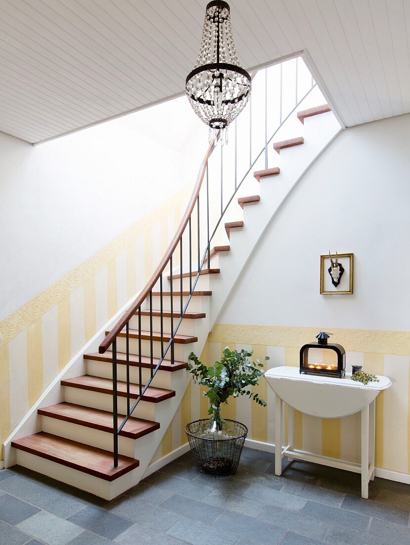 Steep staircase and dado painted in yellow stripes in foyer