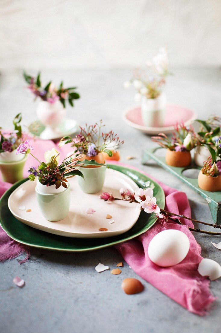Posies arranged in empty egg shells on table