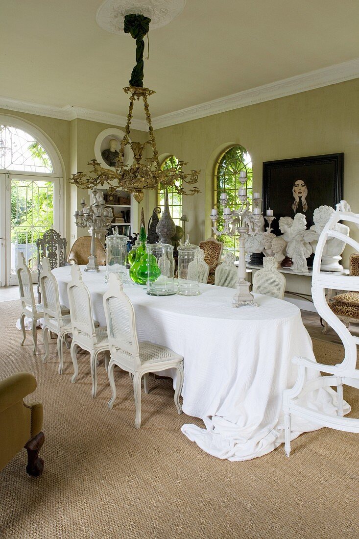 Long oval dining table and Baroque chairs in grand dining room