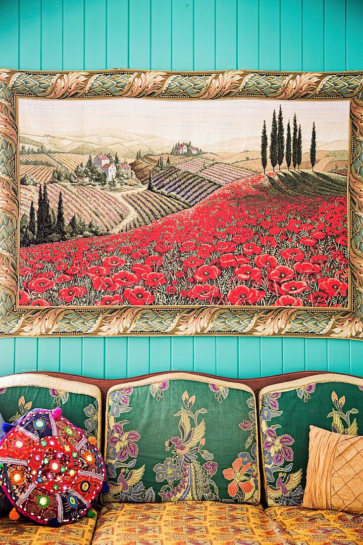 Bild von toskanischer Landschaft über Sofa mit gemustertem Bezug