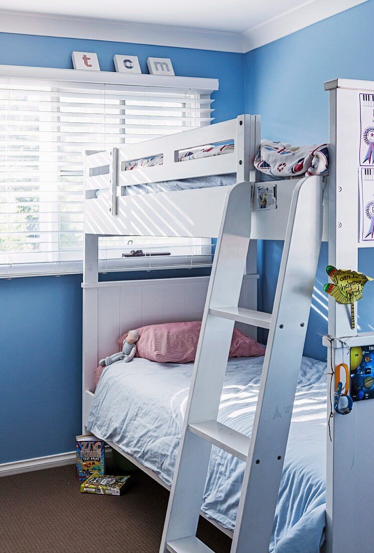 Weißes Etagenbett im Kinderzimmer mit blauen Wänden
