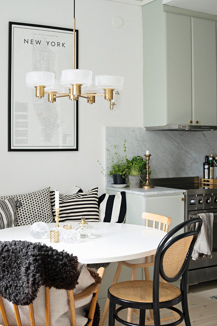 Round white table, bentwood chairs and retro lamp next to kitchen counter