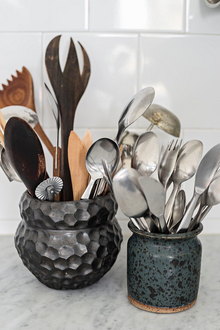 Besteck und Küchenwerkzeuge in Keramikgefäßen