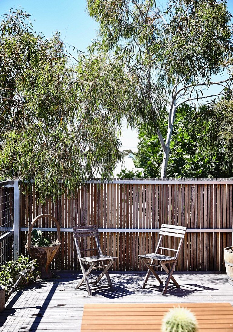 Summery terrace with two weathered folding chairs