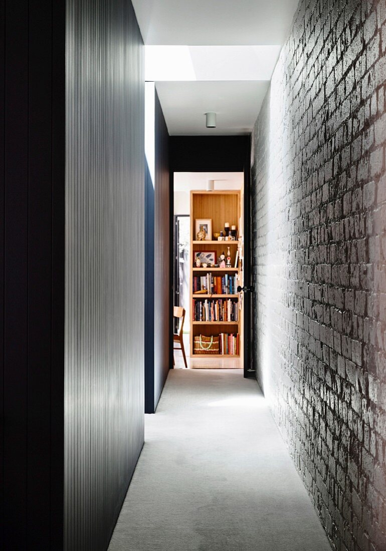 Narrow hallway with brick wall and gray carpeting