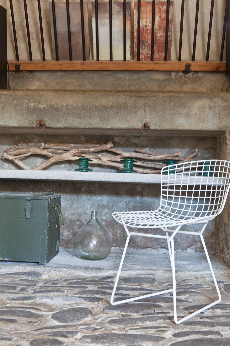 Stone floor, driftwood and white wire chair in rustic ambiance