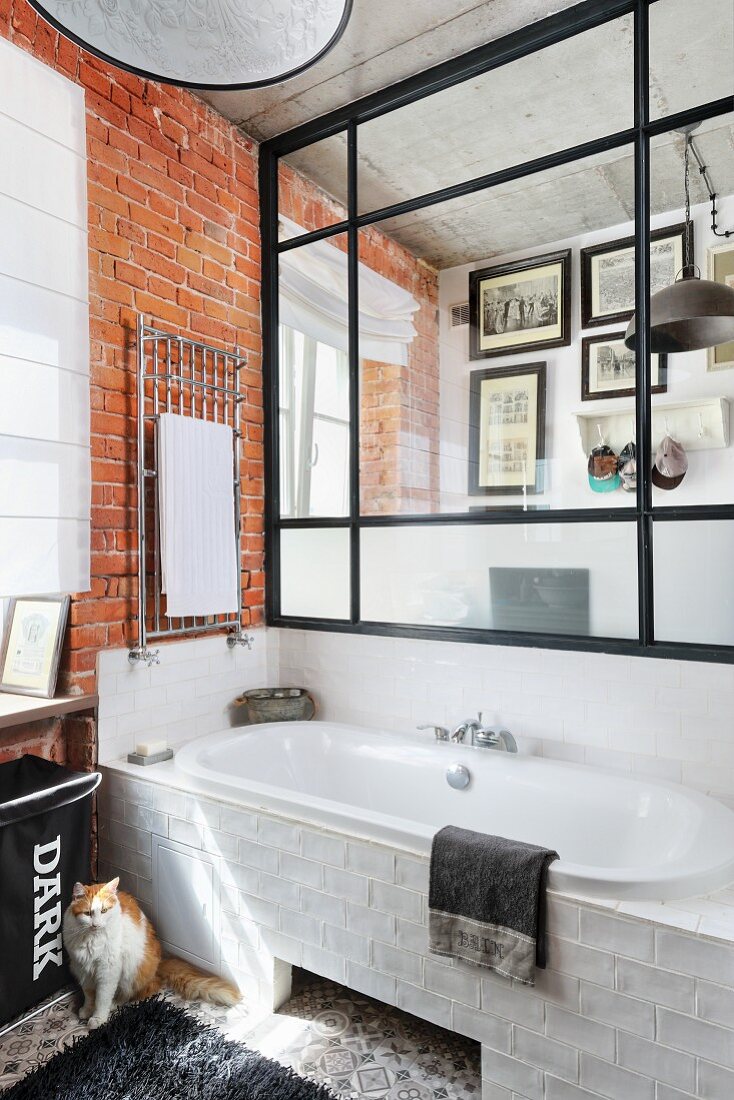 Badezimmer mit Glas-Stahl-Wand über der Badewanne