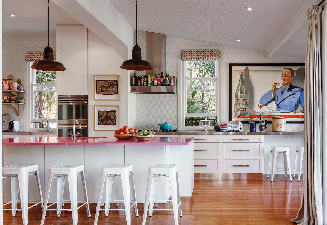 Pink kitchen countertop on kitchen counter with bar stool in open kitchen with retro flair
