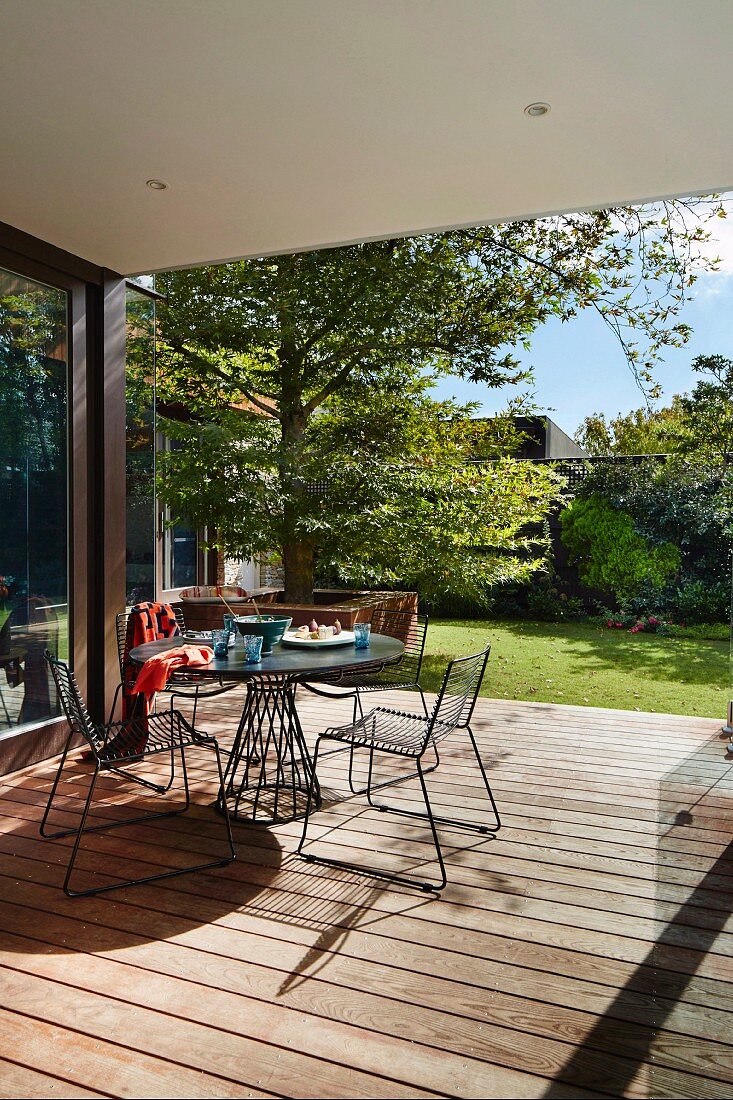 Filigrane Gartenmöbel aus Metall auf der Terrasse zum Garten