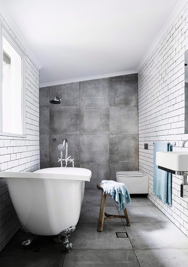 Bad mit großformatigen grauen Fliesen an Boden und Wand