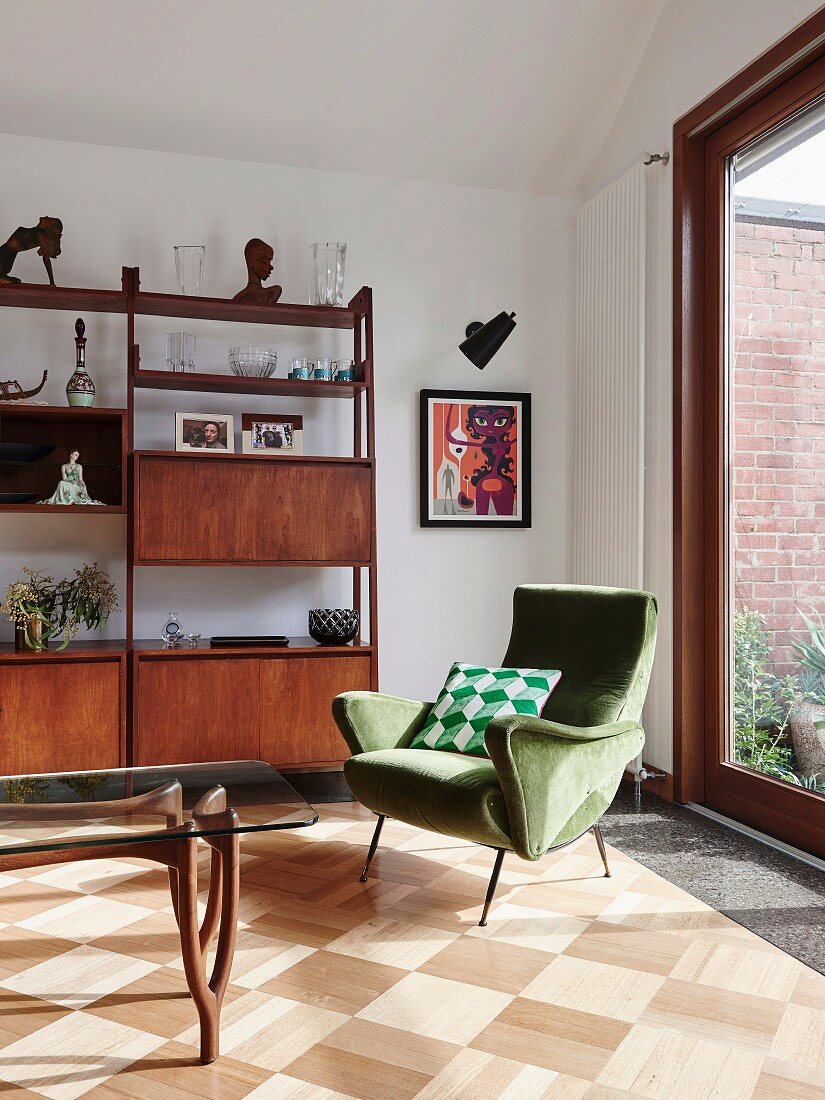 Green armchair in retro living room with parquet floor