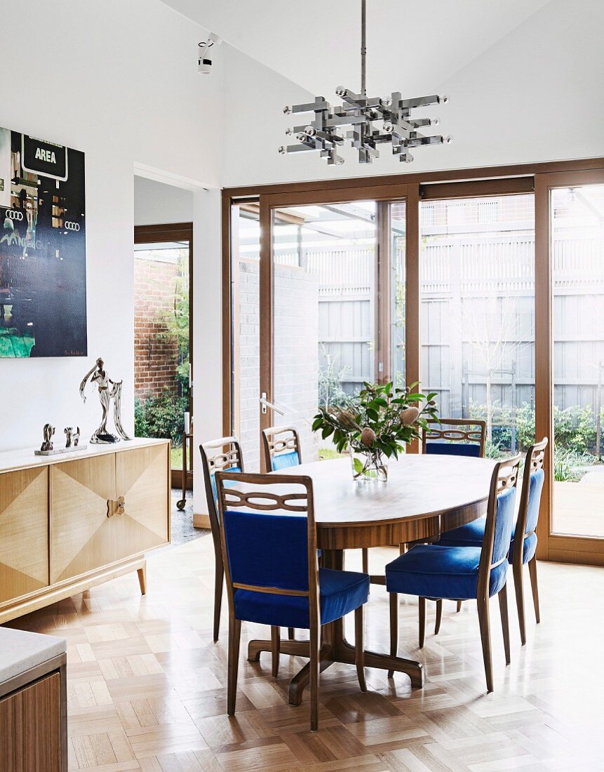 Ovaler Tisch und Stühle mit blauen Samtbezügen im Esszimer