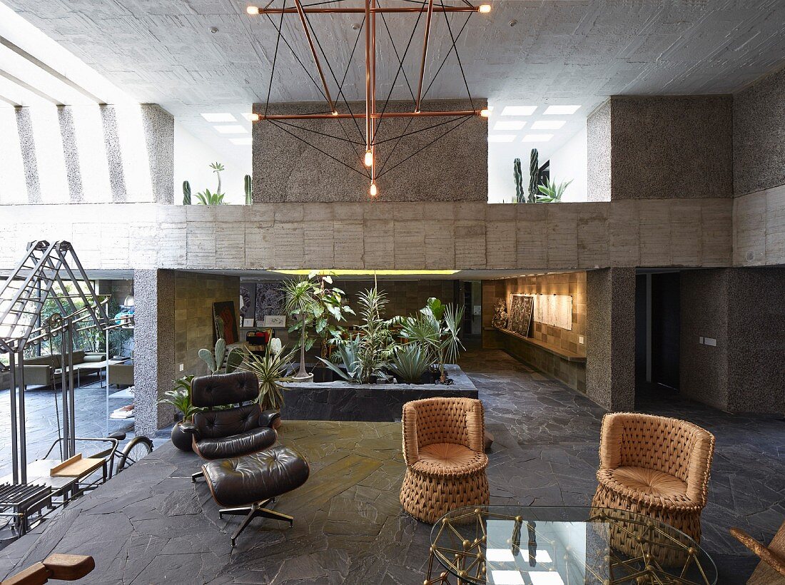 Offener Wohnraum mit Designermöbeln im Haus aus Beton