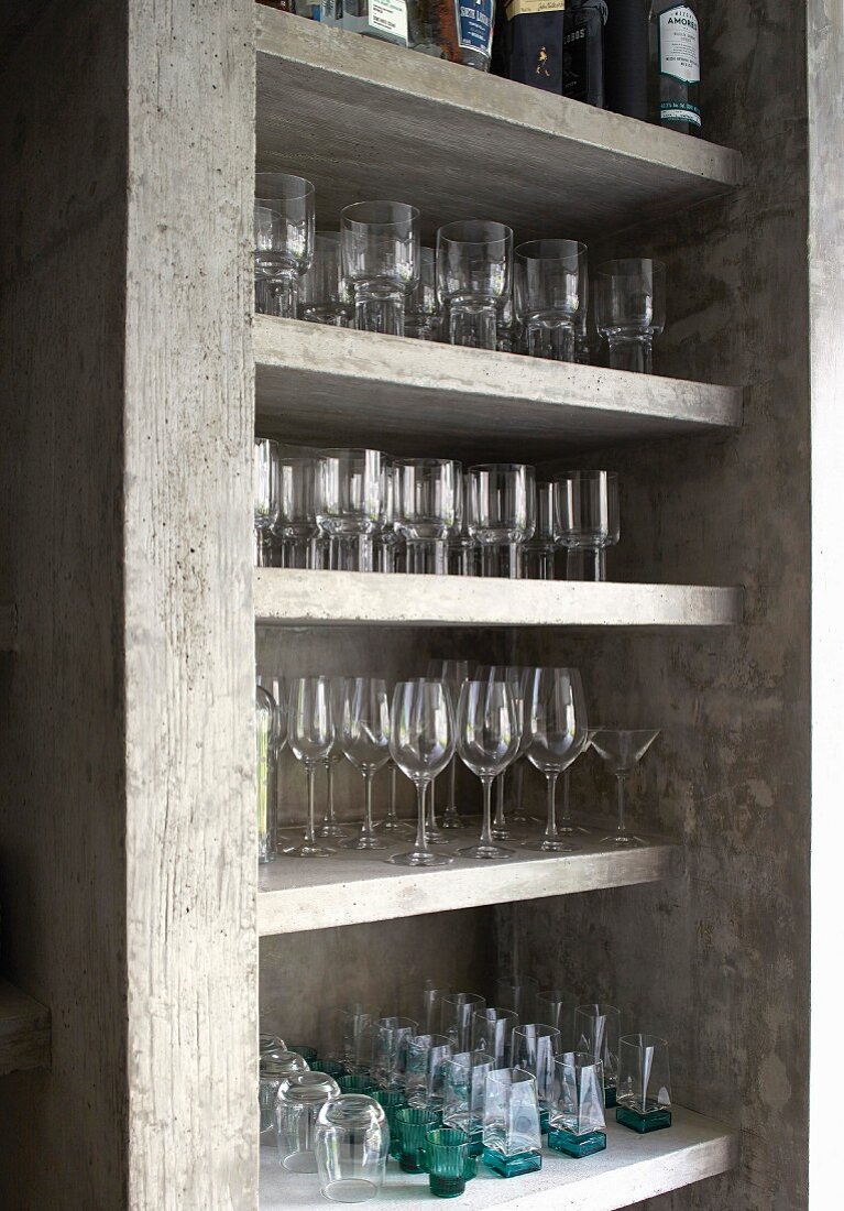 Neatly arranged glasses on concrete shelves