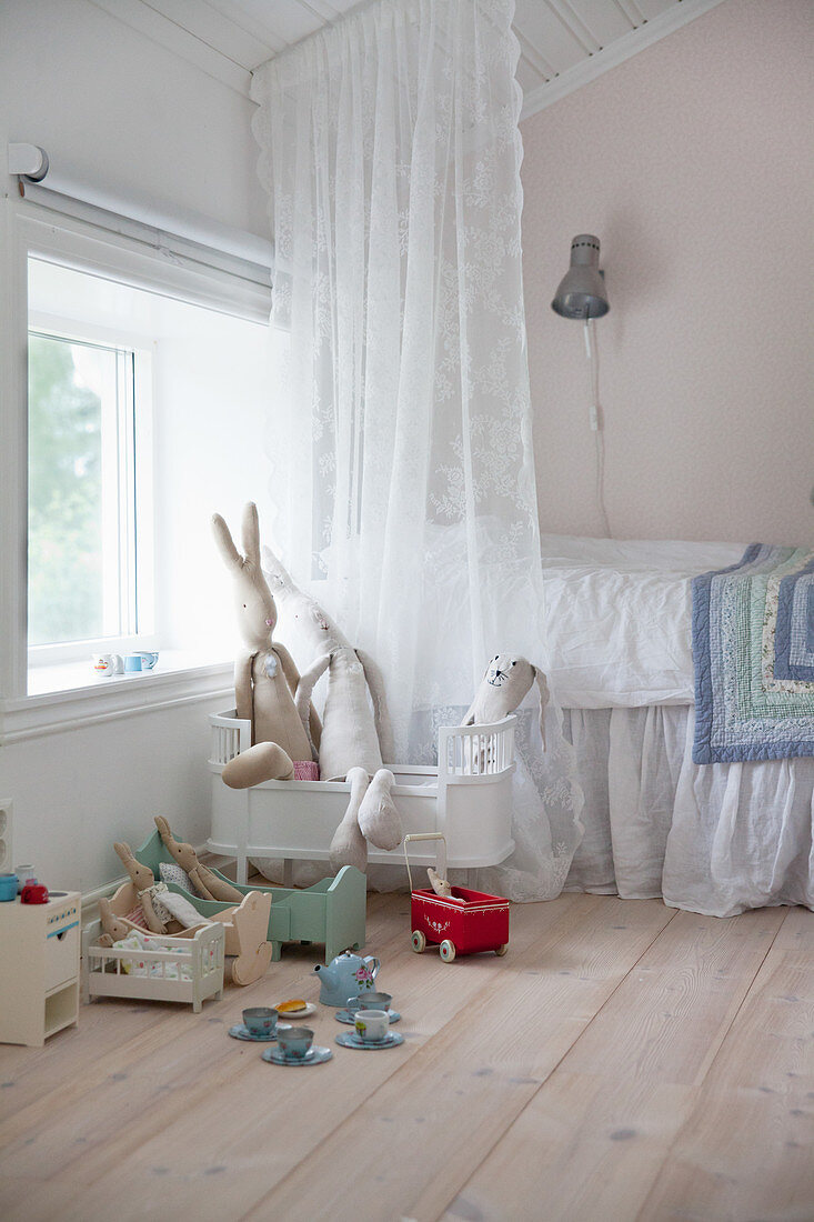 Puppenbetten vor dem Bett im Kinderzimmer