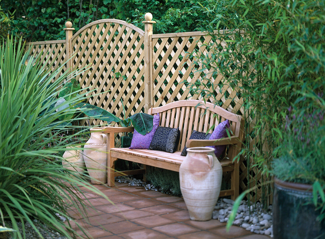 Garden bench in front of wooden lattice for privacy