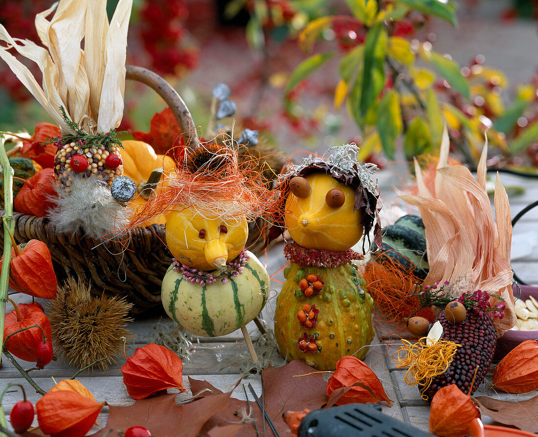 Figures are made from ornamental gourds and ornamental corn, rose hips as eyes, foliage cap