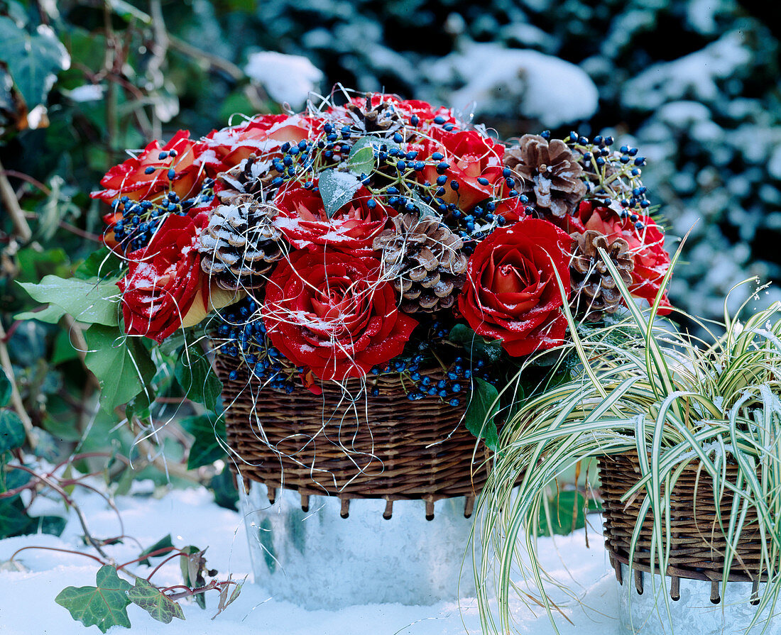 Bouquet made of red roses, snowball berries, cones on wire, tinsel, carex (sedge)