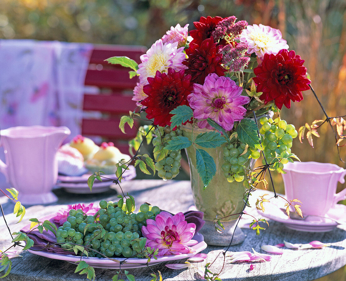 Herbststrauß in grüner Vase mit Dahlia (Dahlien) in rosa und weinrot