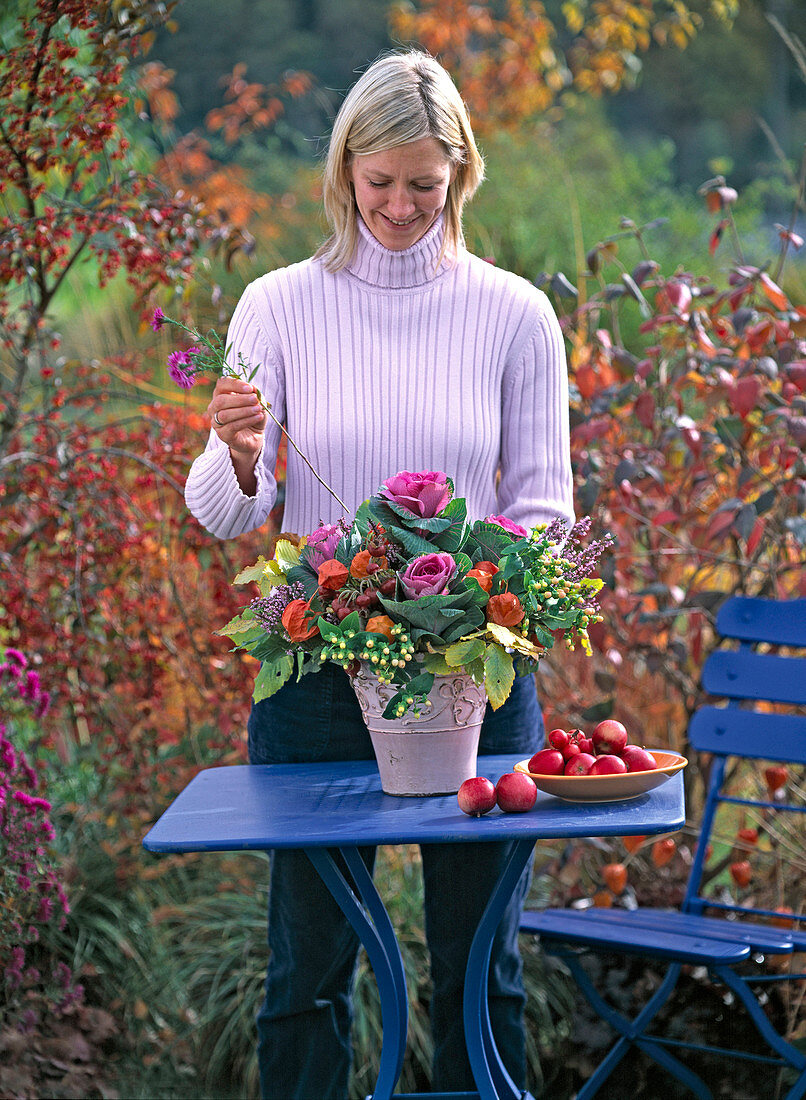 Young woman puts autumn bouquet