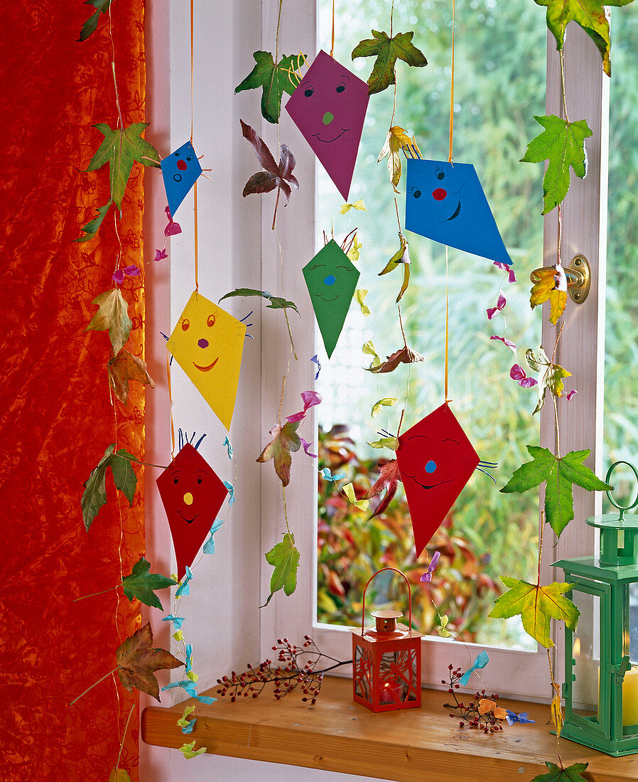 Paper kite and leaves on wire as window decoration, pink
