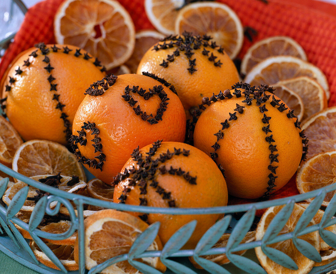 Citrus (oranges) peppered with cloves on metal tray