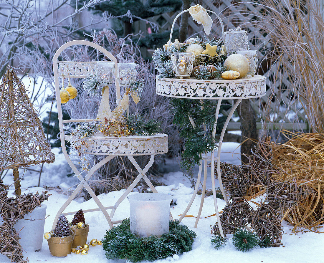 weiße Garnitur im Schnee mit weihnachtlichem Arrangement mit Pinus (Kiefer)