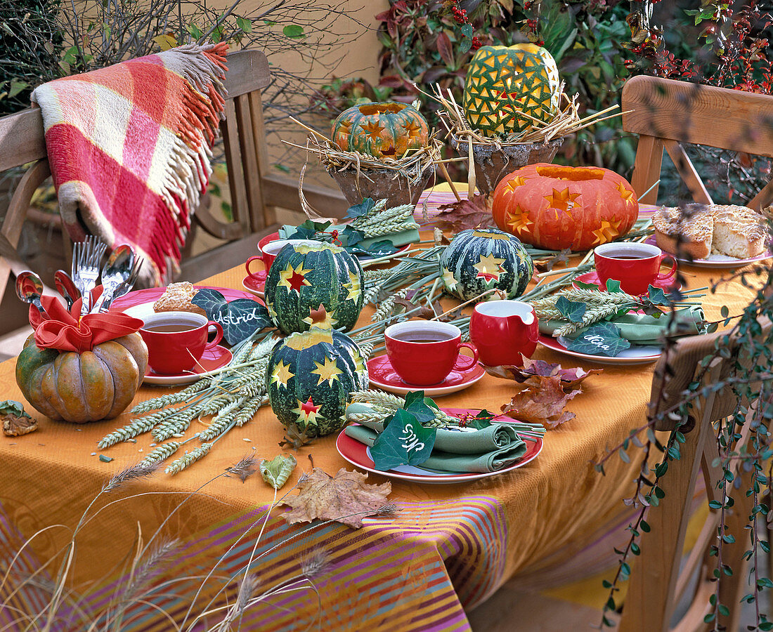 Herbstliche Tischdekoration mit Cucurbita (Kürbis) mit eingestanzten Formen