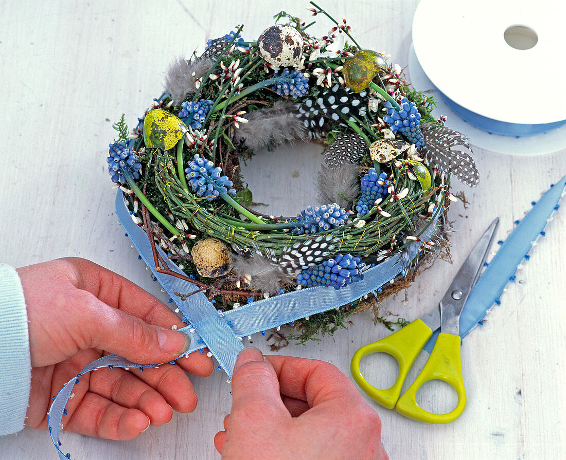 Easter wreath with grape hyacinths, feathers and eggs