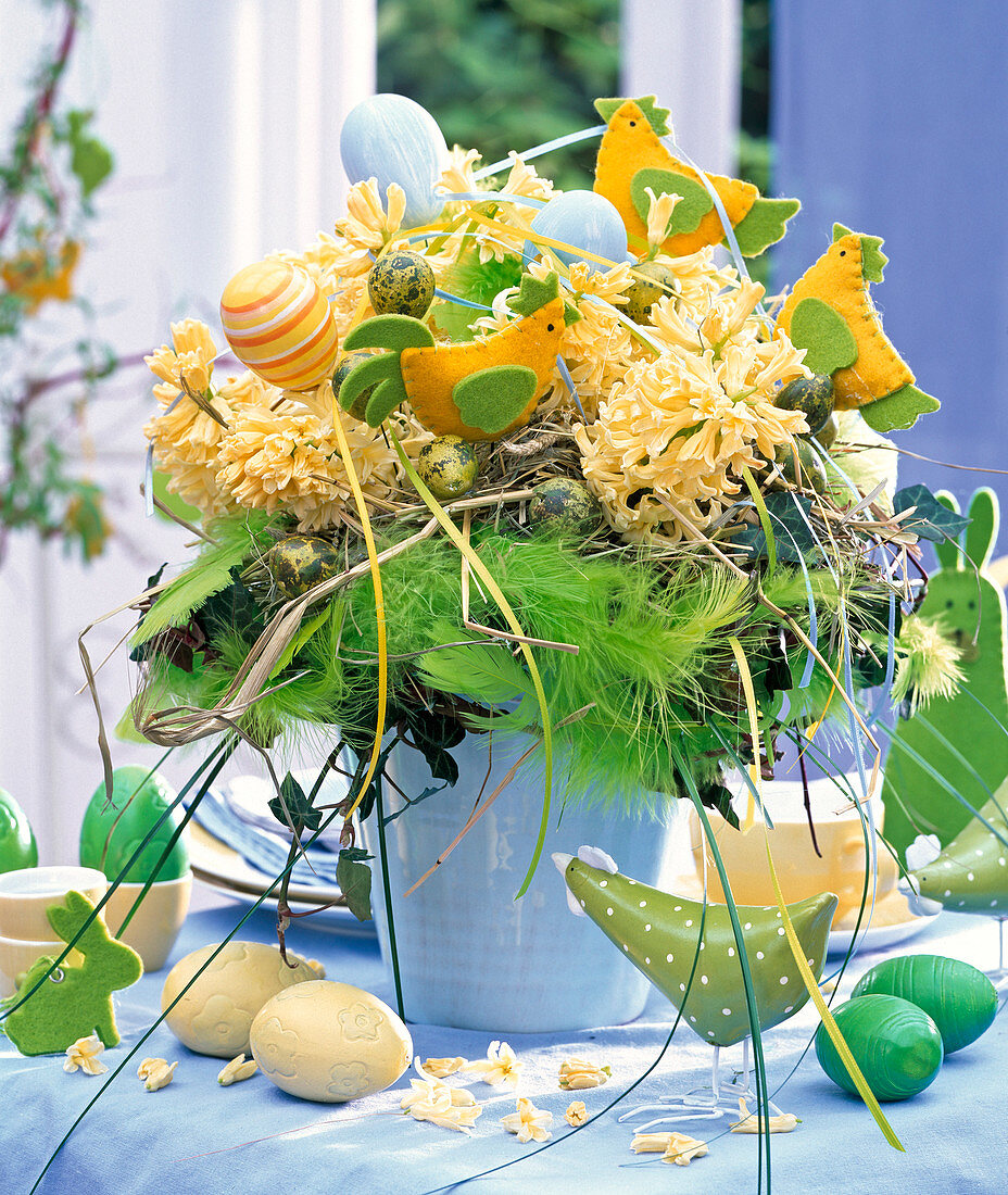 Osterstrauß aus gelben Hyacinthus (Hyazinthen) in hellblauer Vase