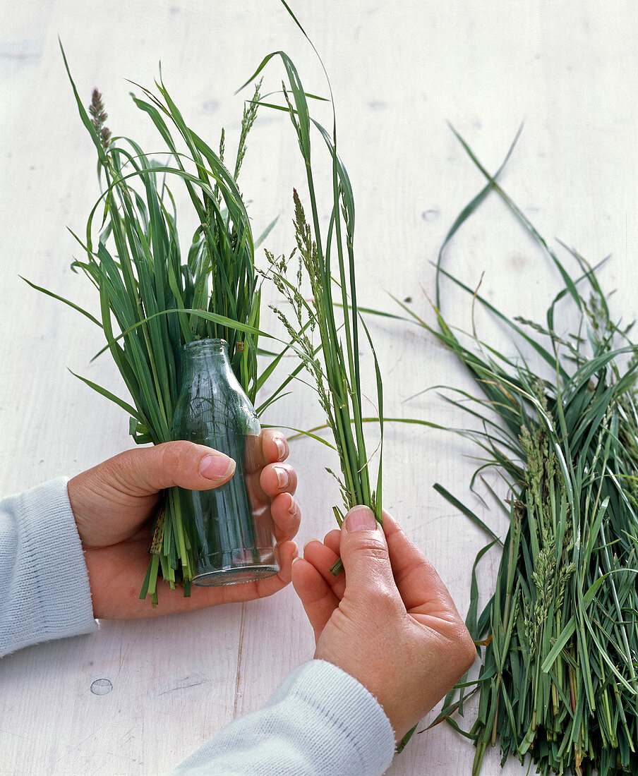 Bouquets in bottles on the grass coat