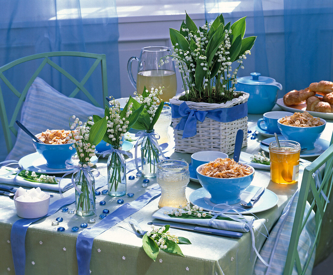 Tischdekoration mit Convallaria (Maiglöckchen), blaue Schalen