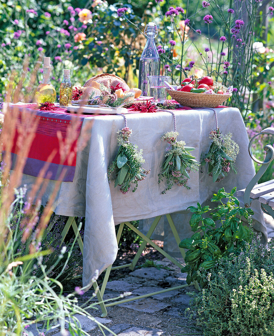 Herbs as table decoration with bouquets of salvia, rosmarinus
